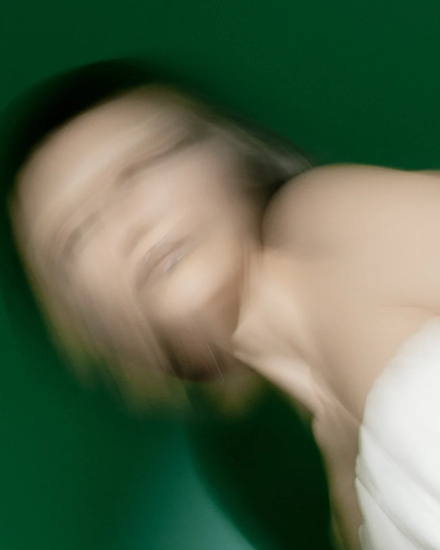 Long-exposure close-up of a tilted head against a green backdrop, SHOT Magazine editorial photographed by Ina Cenusa