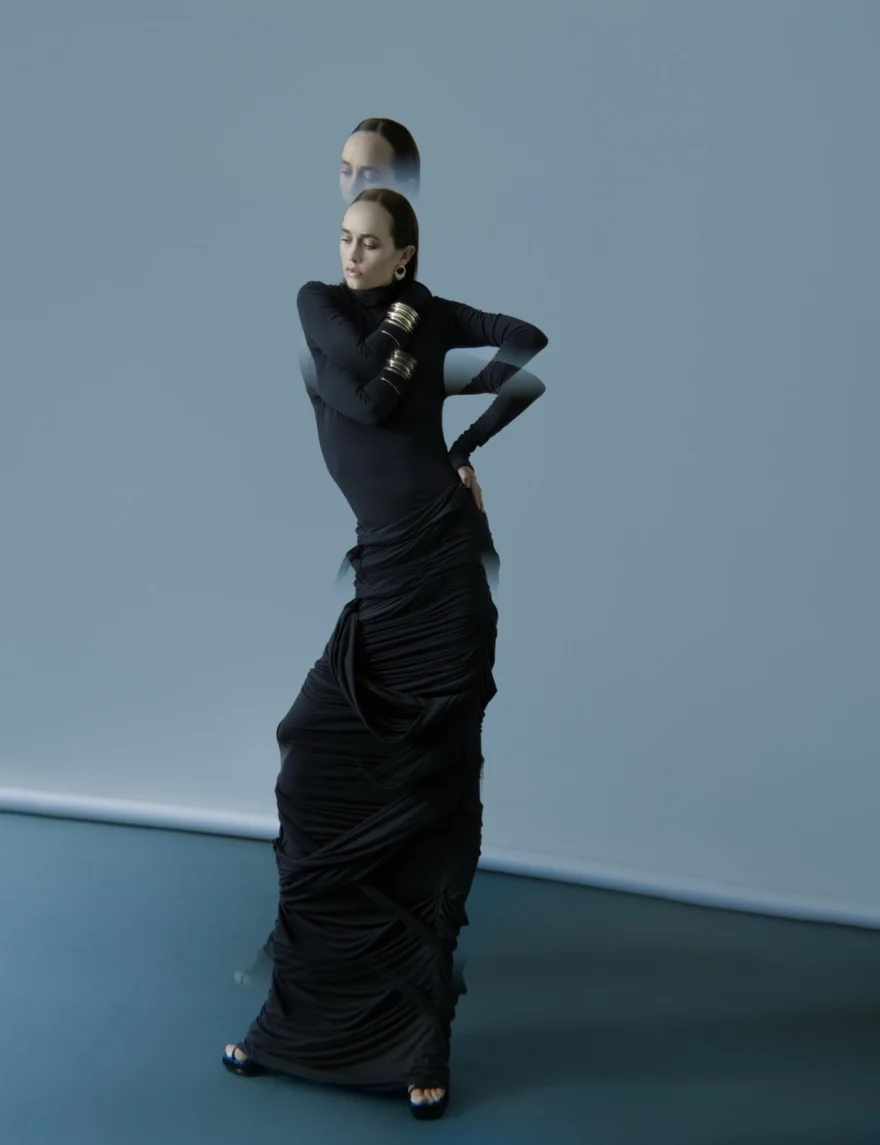 Dancer in a long black gown standing against a blue-grey studio backdrop, SHOT Magazine editorial photographed by Ina Cenusa