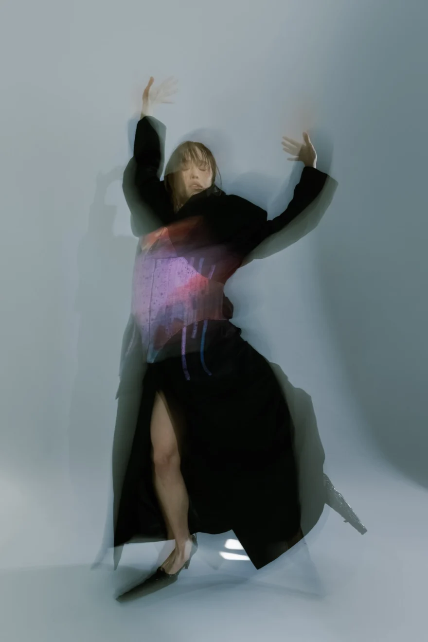 Long-exposure image of a dark skirt in movement against a pale wall, SHOT Magazine editorial photographed by Ina Cenusa