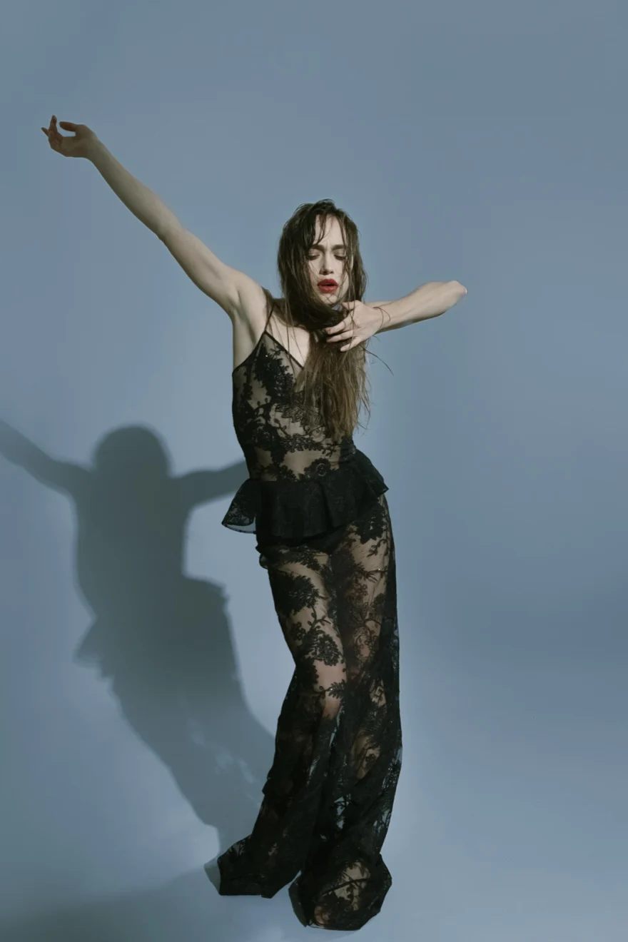 Dancer in a black lace gown reaching upward, shadow cast on the backdrop, SHOT Magazine editorial photographed by Ina Cenusa