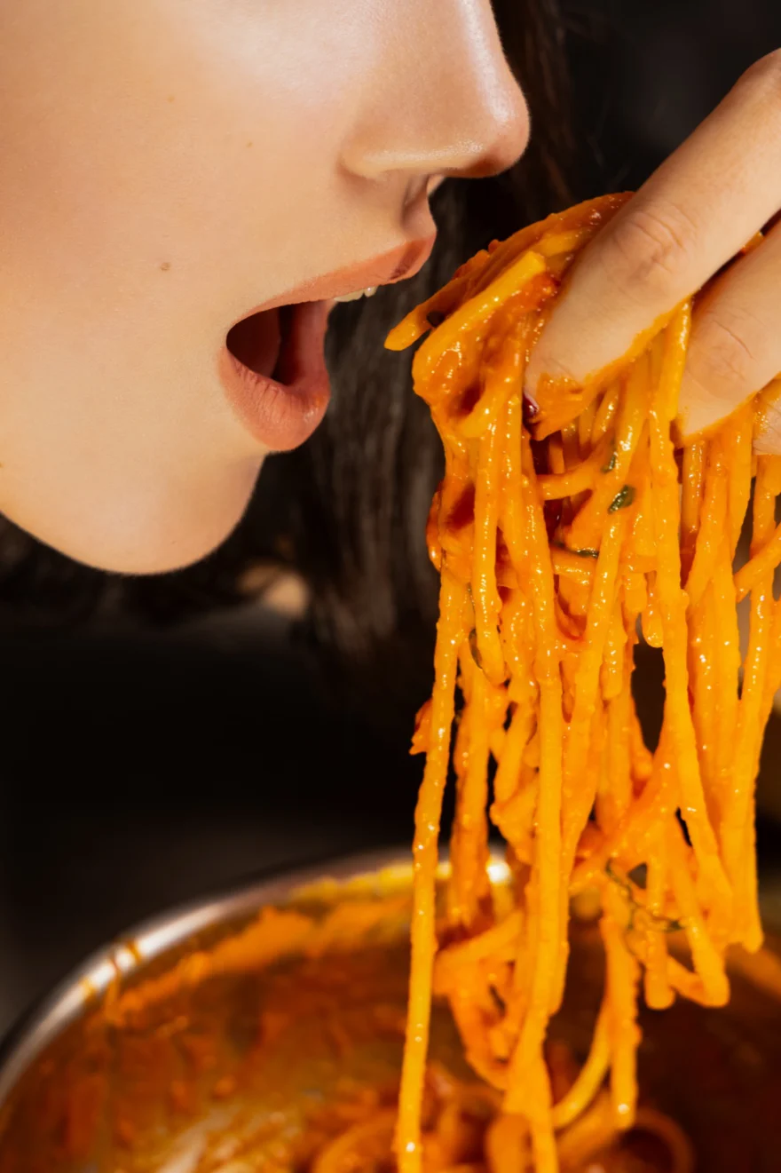 Profile of a mouth lifting a forkful of spaghetti, appetite in close up, Fuoco Sacro campaign photographed by Ina Cenusa