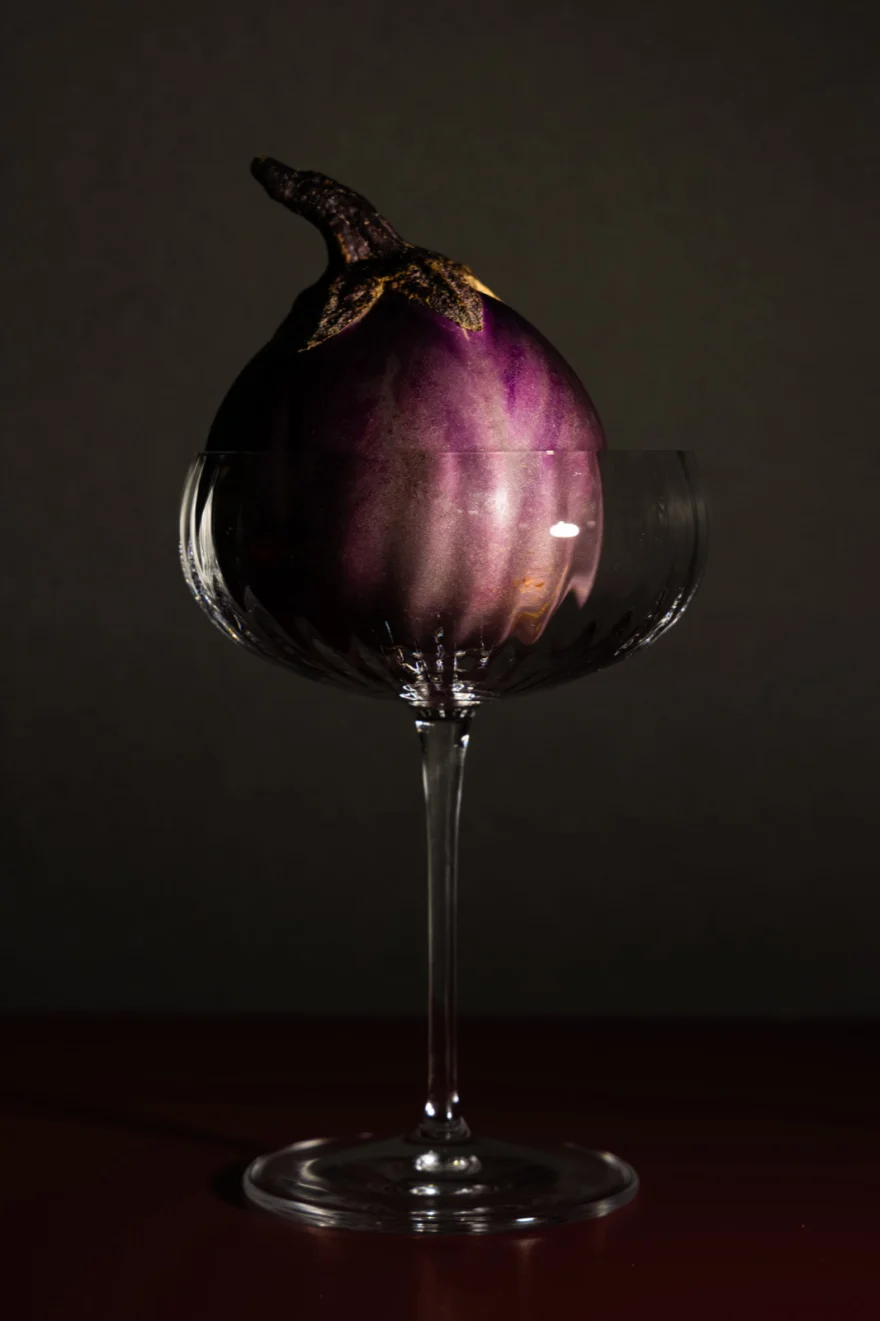 Red wine swirling in a glass against a black background, Fuoco Sacro campaign photographed by Ina Cenusa