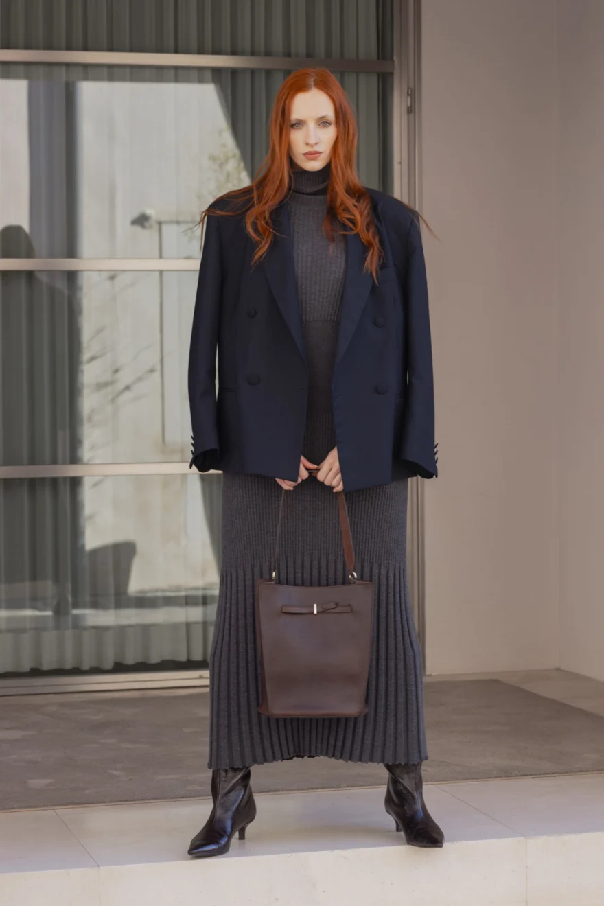 Model in a navy blazer carrying a brown leather bag, Biebi campaign photographed by Ina Cenusa