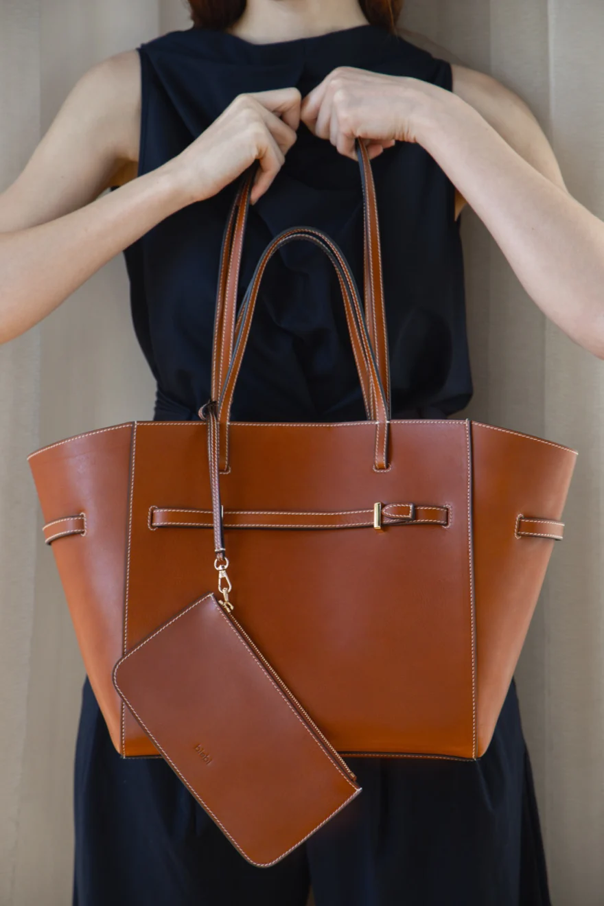 Full-length look with a leather bag against a pale interior, Biebi campaign photographed by Ina Cenusa
