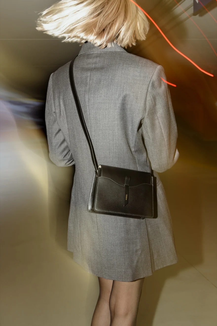 Motion-blurred back view of a blazer with a crossbody bag, Noesi campaign photographed by Ina Cenusa