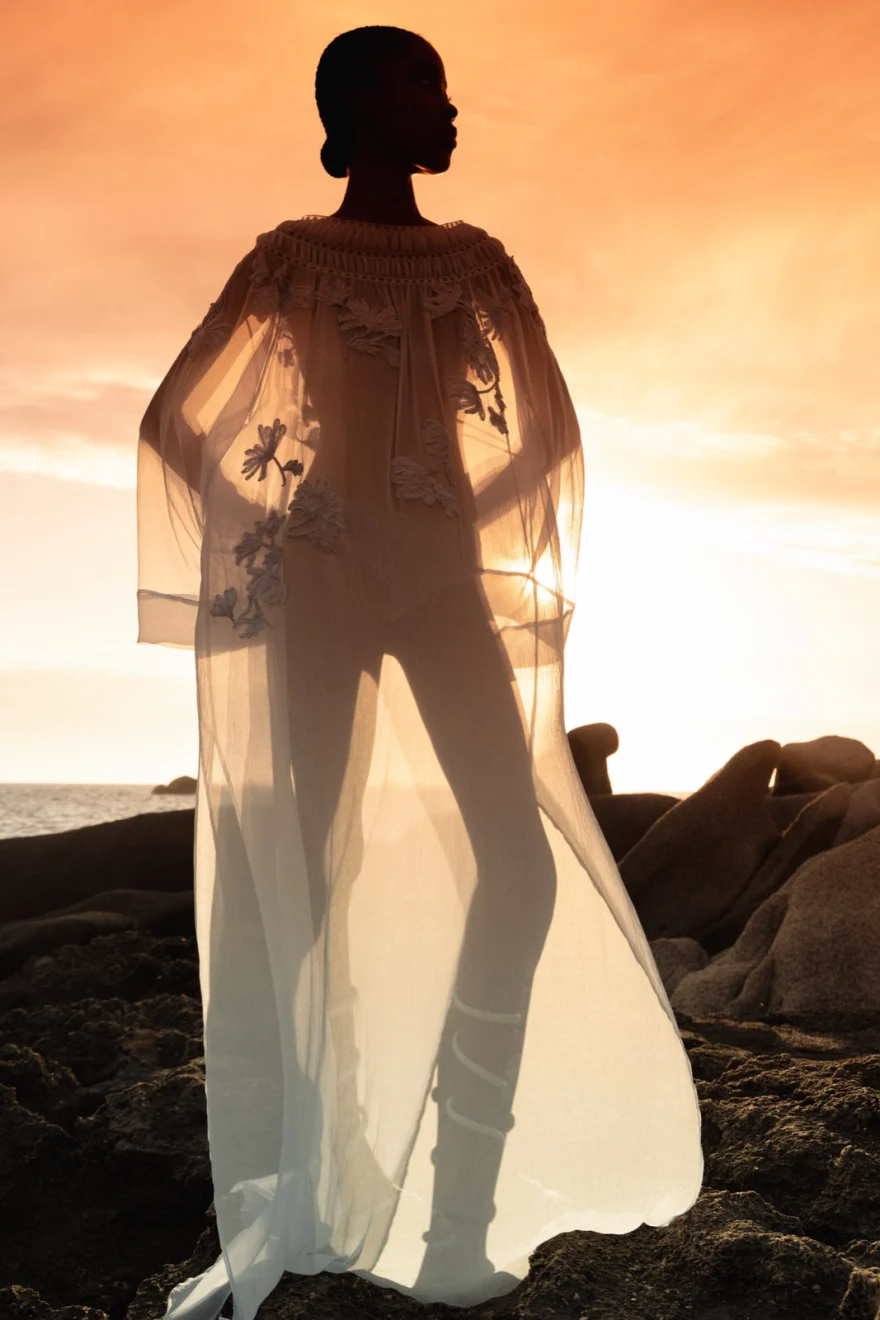 Model in a white coat among the rocks, Ermanno Scervino campaign photographed by Ina Cenusa