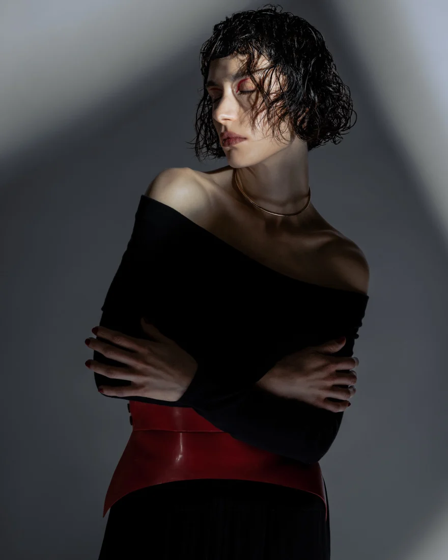 Model in an off-shoulder black top with wet-look curls, Philip Martin's campaign photographed by Ina Cenusa