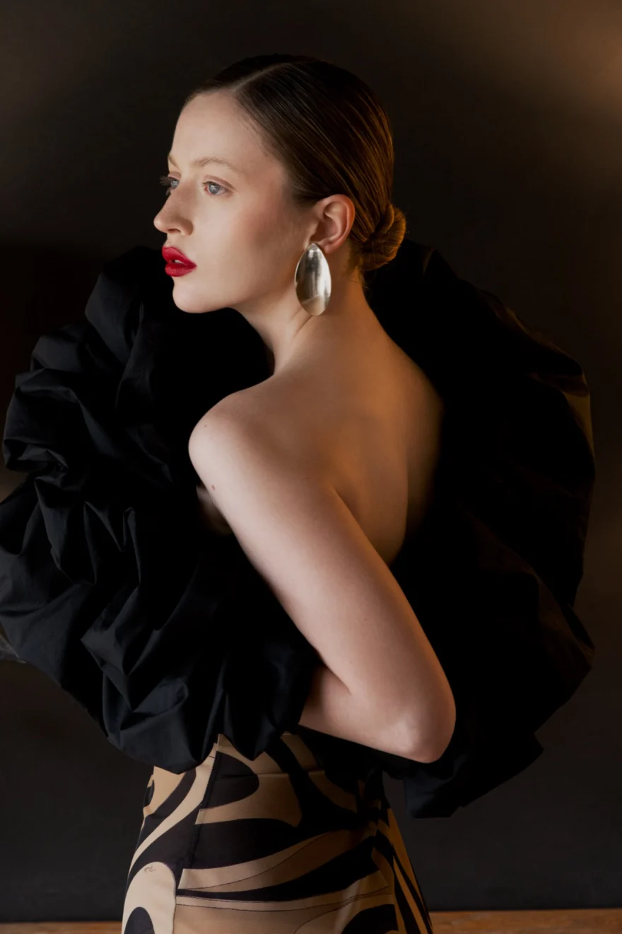 Bare back with a ruffled black jacket slipping from the shoulders and a statement earring, SHOT Magazine editorial photographed by Ina Cenusa