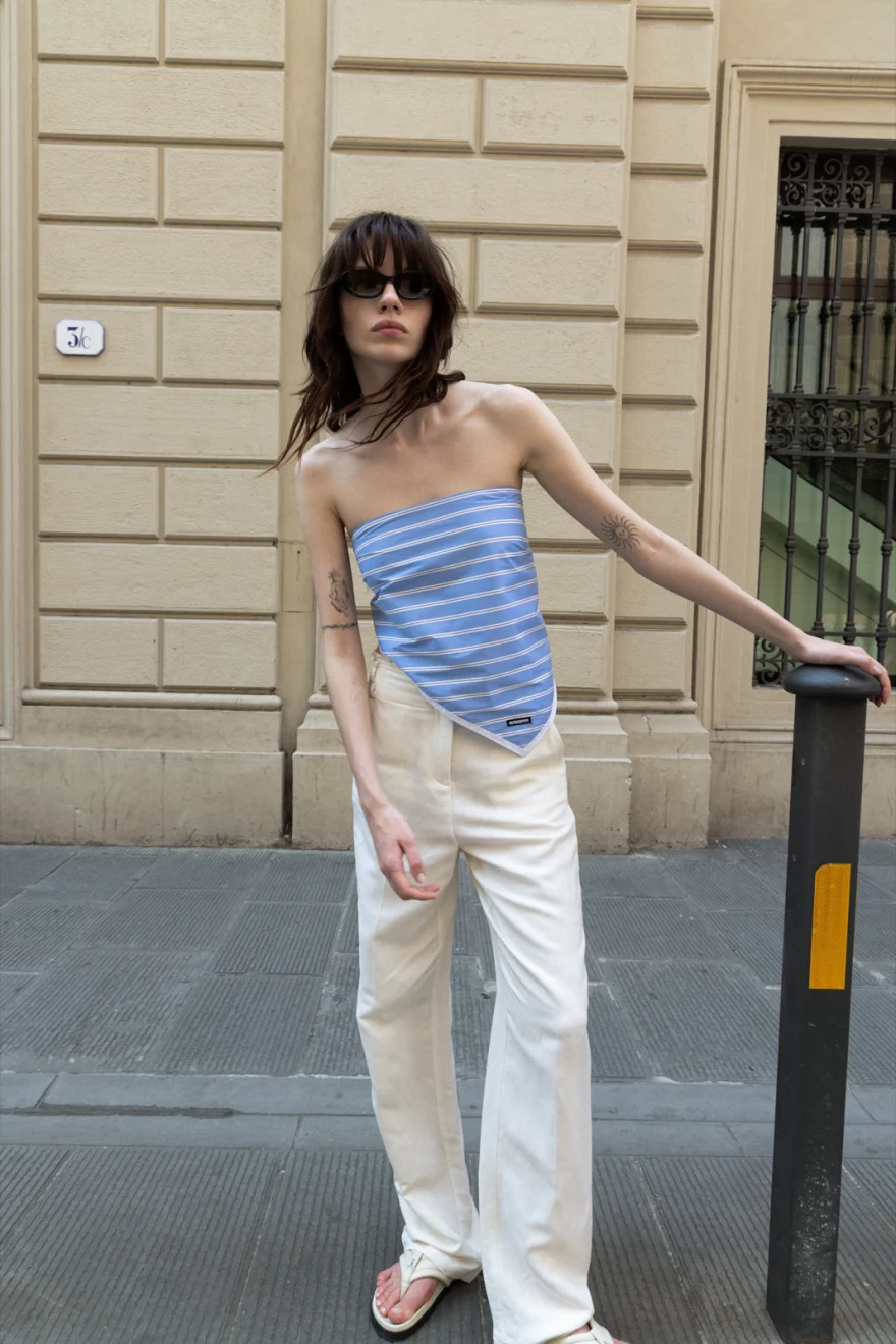 Model in a blue bandeau top and white jeans on the street, Patrizia Pepe campaign photographed by Ina Cenusa