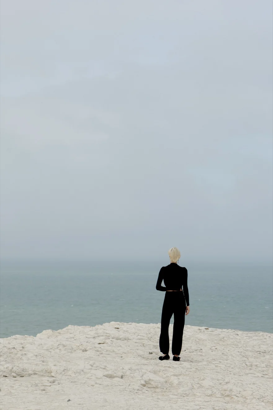 Distant figure in black at the edge of the chalk cliffs, Ermanno Scervino campaign photographed by Ina Cenusa