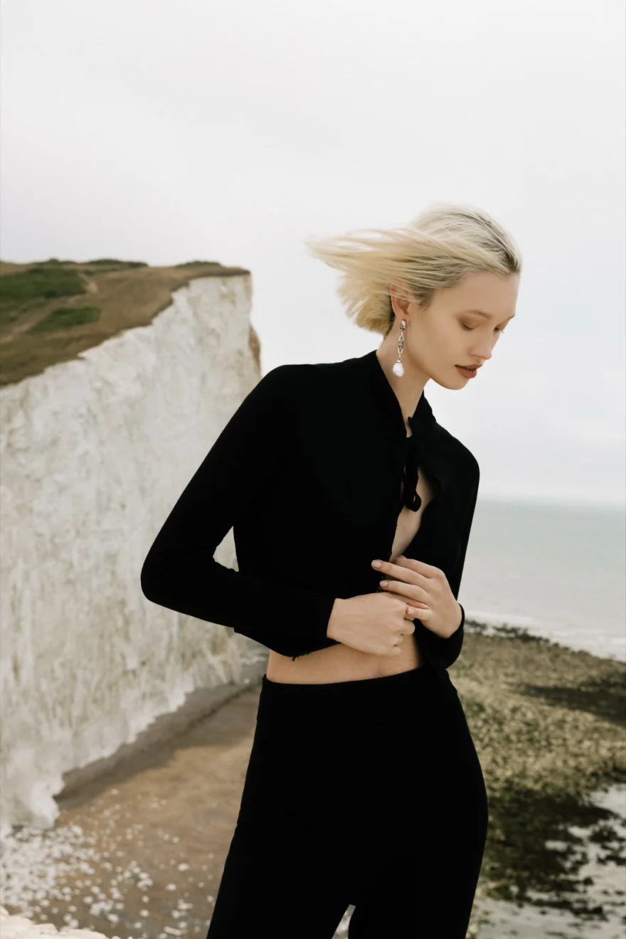 Model in a black gown with a long train on the clifftop, Ermanno Scervino campaign photographed by Ina Cenusa