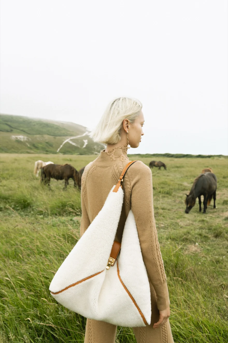 Model in black knitwear against the white chalk cliff, Ermanno Scervino campaign photographed by Ina Cenusa