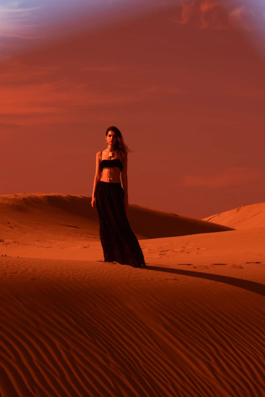 Figure in a long black dress alone on a deep red dune, Ermanno Scervino beachwear campaign in Morocco, photographed by Ina Cenusa