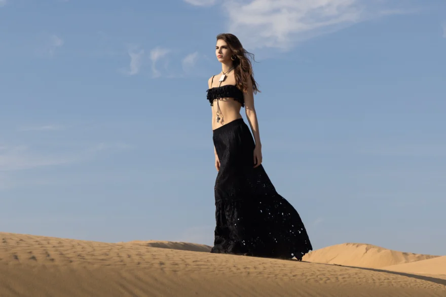 Long black dress lifted by the wind on the crest of a dune, Ermanno Scervino campaign photographed by Ina Cenusa