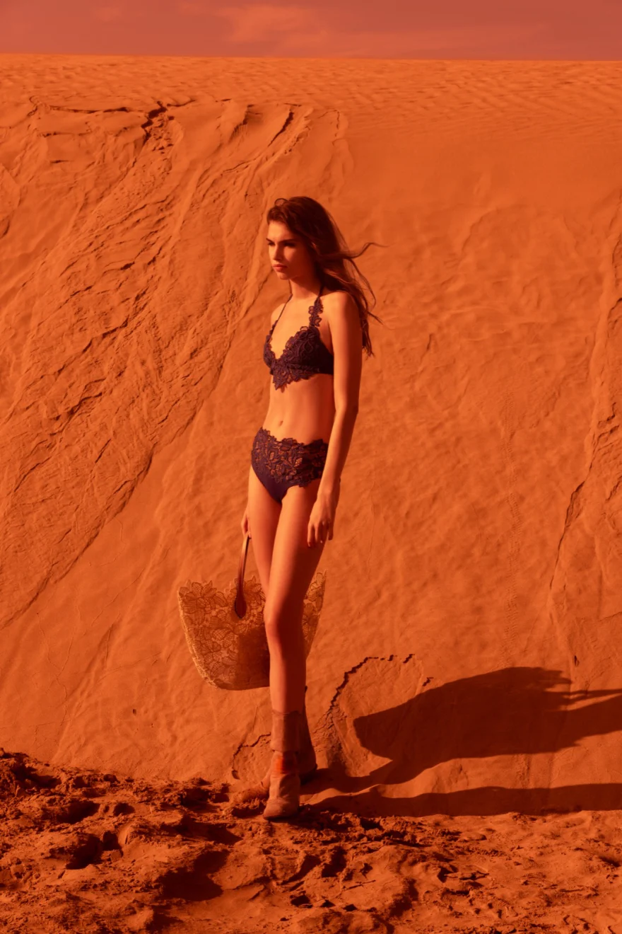 Blue bikini against an intensely red dune wall, Ermanno Scervino campaign photographed by Ina Cenusa