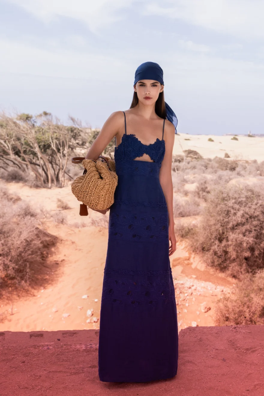 Long navy dress with a woven straw bag on red ground, Ermanno Scervino campaign photographed by Ina Cenusa