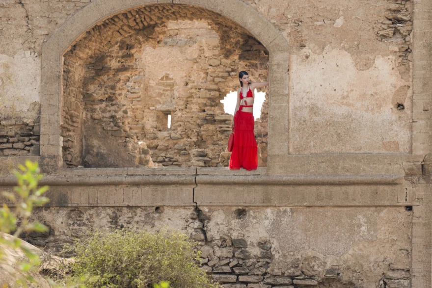 Wide view of the ruins with a small red figure in the archway, Essaouira, Ermanno Scervino campaign photographed by Ina Cenusa
