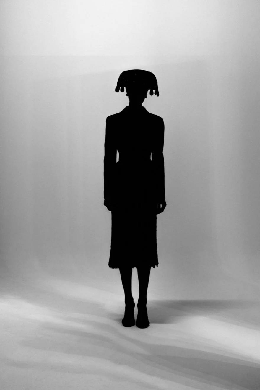Dark silhouette with a wide hat against a pale wall, SHOT Magazine editorial photographed by Ina Cenusa
