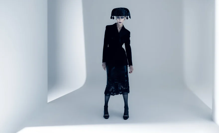 Black tailoring and a sculpted headpiece in a white studio corner, SHOT Magazine editorial photographed by Ina Cenusa