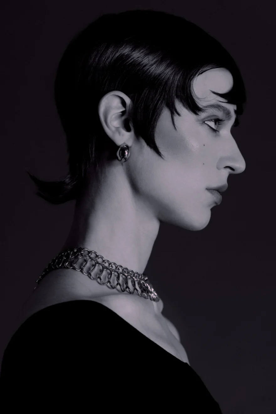 Profile portrait with a heavy chain choker and cropped dark hair, SHOT Magazine editorial photographed by Ina Cenusa