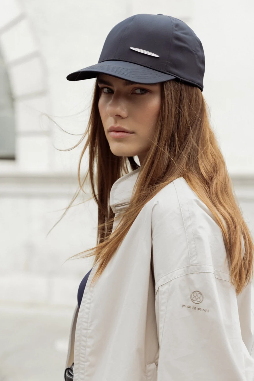 Model in a black cap and cream jacket on a city street, Pagani campaign in Geneva photographed by Ina Cenusa