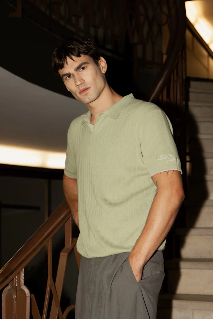 Portrait of a male model in a sage knit polo, staircase behind, Pagani campaign in Geneva photographed by Ina Cenusa